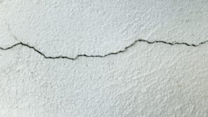 Fissure horizontale sur le mur enduit d'une maison